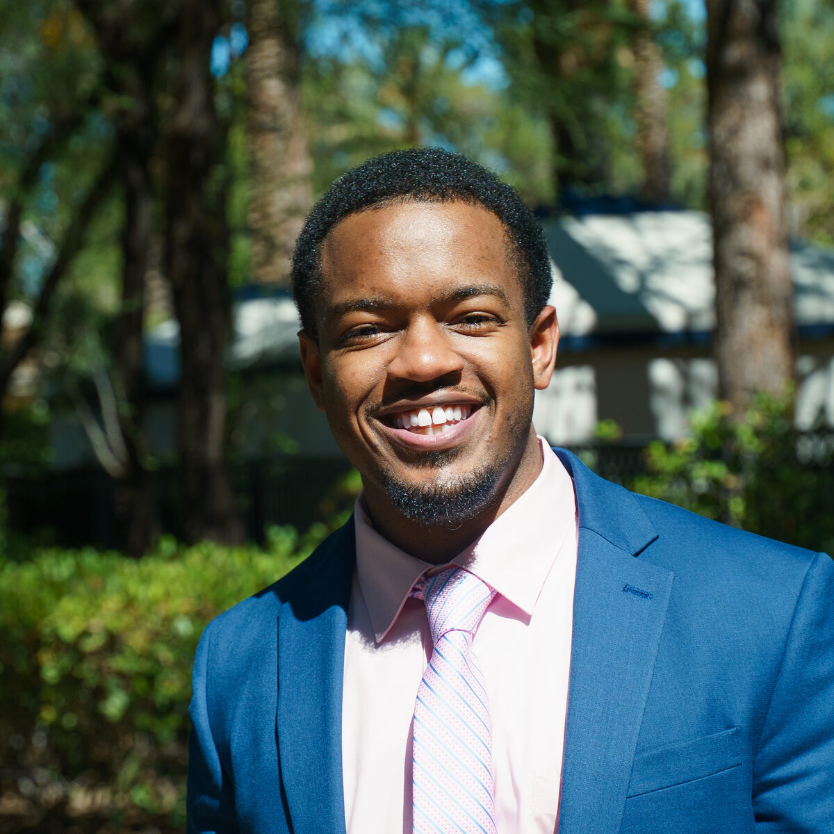 Darian Nwankwo smiling outdoors in a blue suit